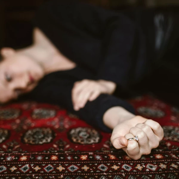 Femme allongée sur un tapis, exprimant le poids d’un chagrin d’amour – séance d’hypnose à Villemomble