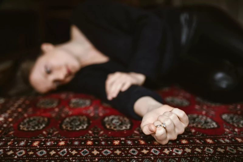 Femme allongée sur un tapis, exprimant le poids d’un chagrin d’amour – séance d’hypnose à Villemomble
