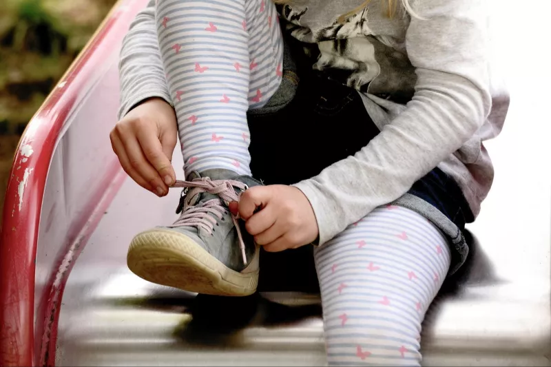 Enfant assis sur un tobogan, illustration de l’accompagnement de l’enfance par l’hypnose ericksonienne.